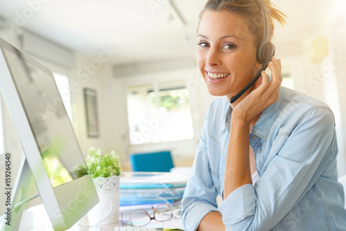 Customer service operator talking on phone in office