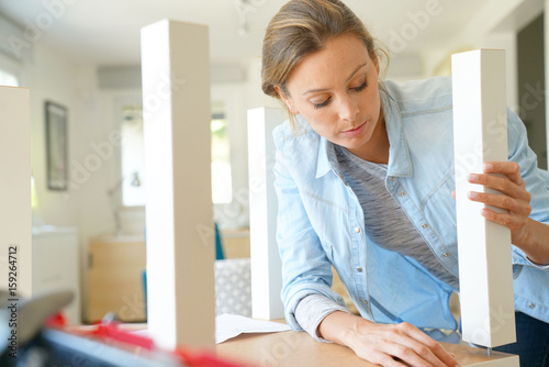 Woman doing DIY work, assembling furniture at home