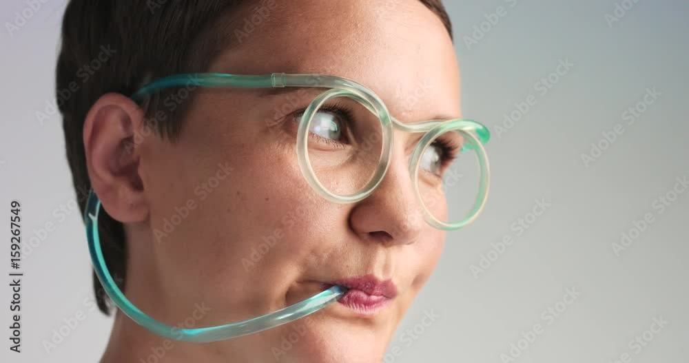 closeup of woman drinking use straw glasses with blue limonade