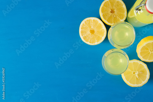 Traditional Italian acoustical leker. Lemonchello of lemons. Blue background. photo