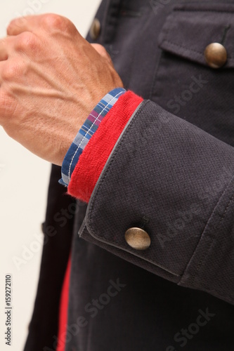 Close up of a man in suit. Man is holding cuff of suit