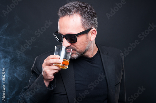 Handsome millionaire enjoying a glass of whiskey