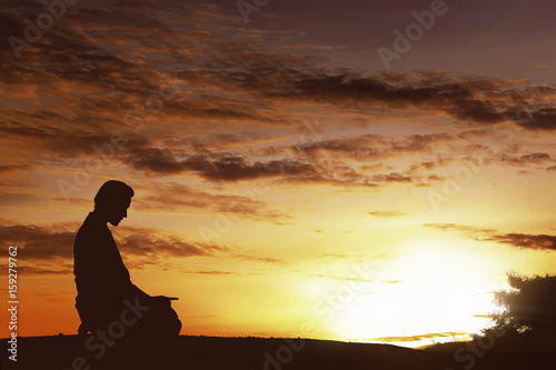 Silhouette of asian muslim man praying on a hilltop