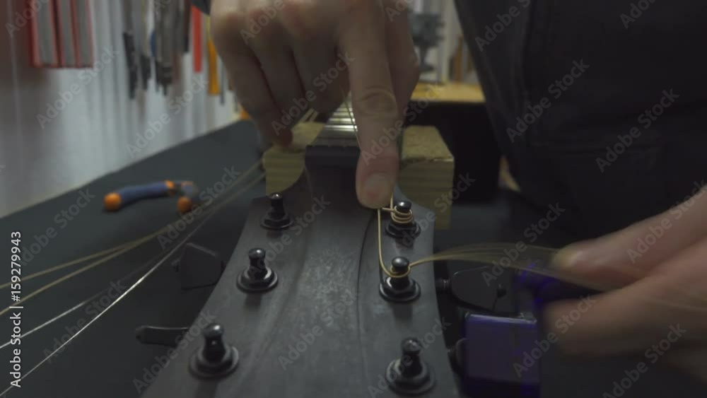 Guitar Maker Installing New Strings on Classical Guitar