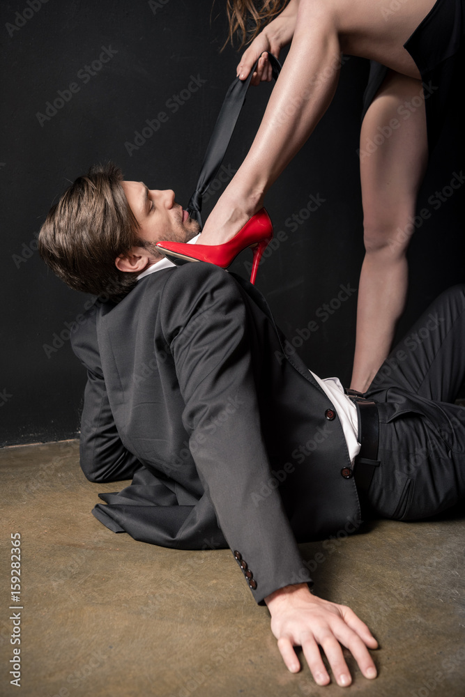 girl in red stilettos dominating on young elegant man in sexual scene