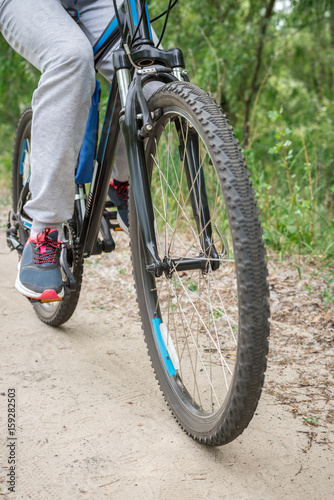 A trip on a mountain bike along the forest path. Sports and the concept of active life in the summer. Vertical frame