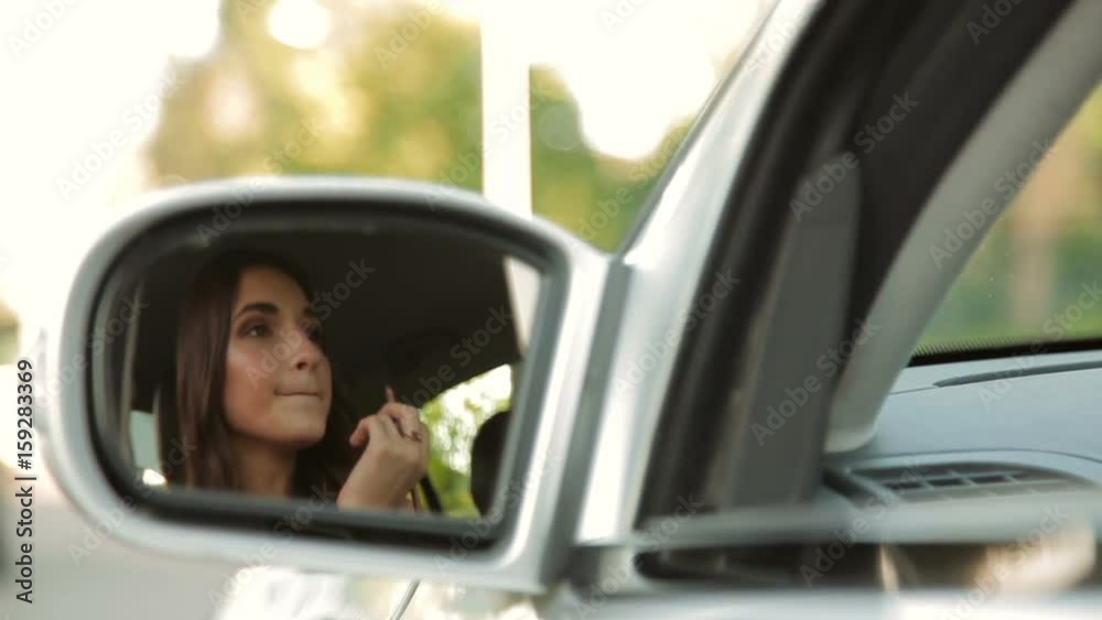 Pretty girl in a car. Cute woman applying lipstick in a car Pretty girl in a car. Cute woman applying lipstick in a car