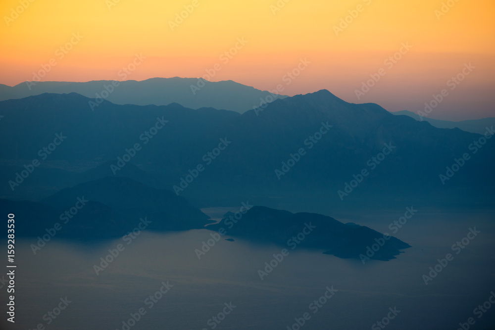 Orange sunset in the mountains. View from a height.