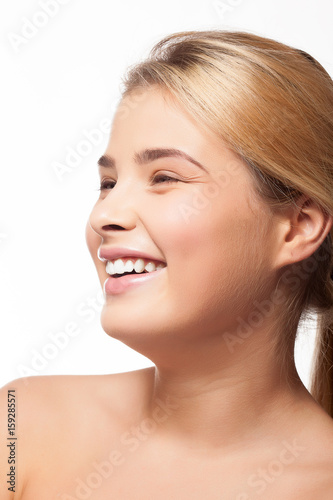 Beautiful girl smiling on white background in studio photo. Perfect white teeth