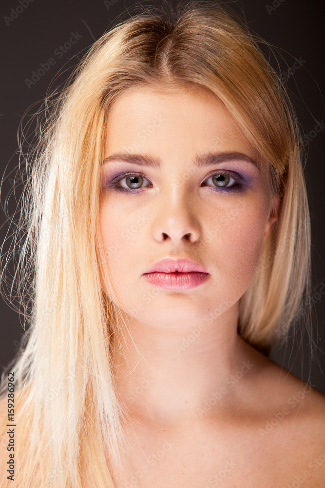 Fototapeta premium Young woman with purple makeup in studio photo. Young beauty. Healthy natural skin