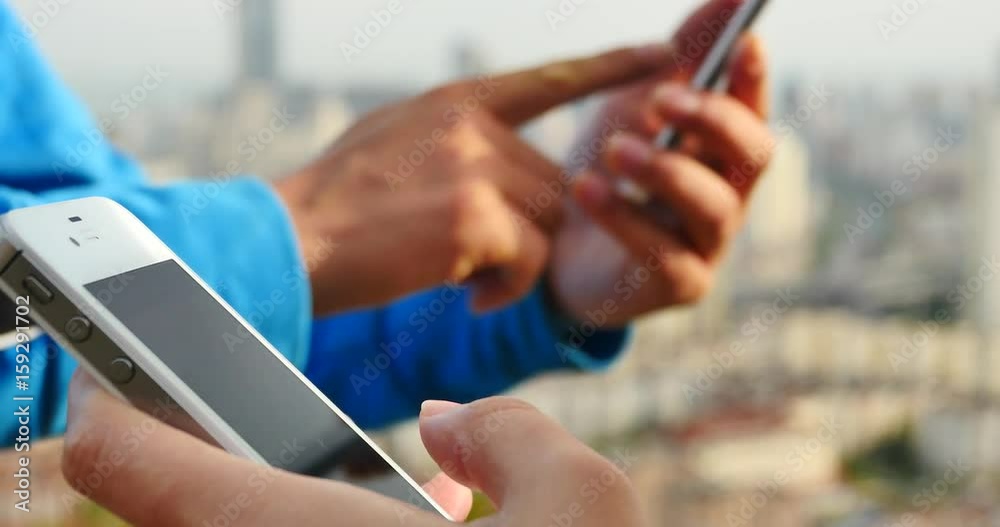 4k human using a smartphone aganist modern urban building background. 