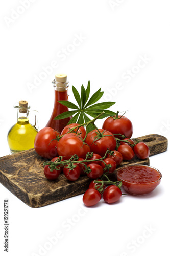 olive oil with ketchup and tomatoes on a wooden board. 