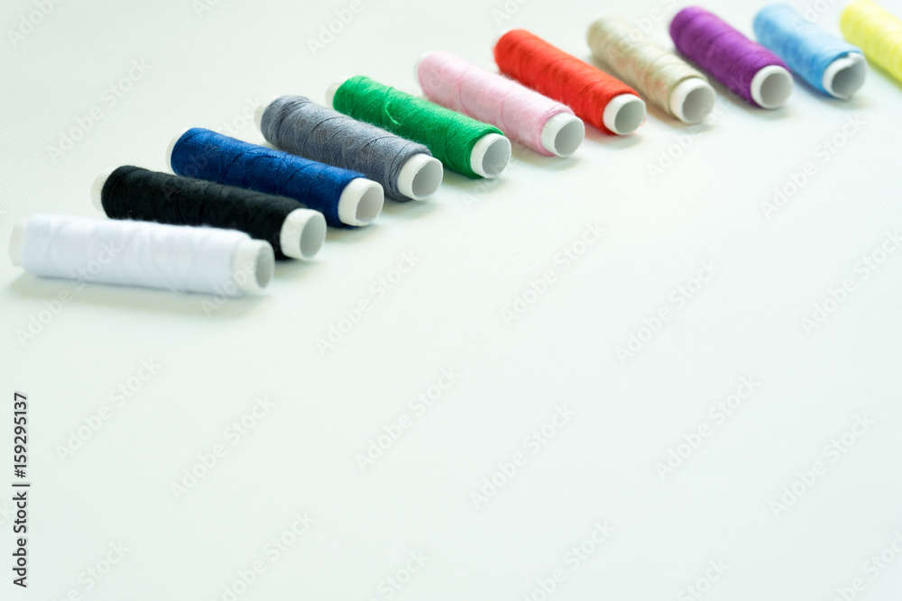 Spools of colours threads or call yarns on rolls for sewing isolated on white background Spools of colours threads or call yarns on rolls for sewing isolated on white background