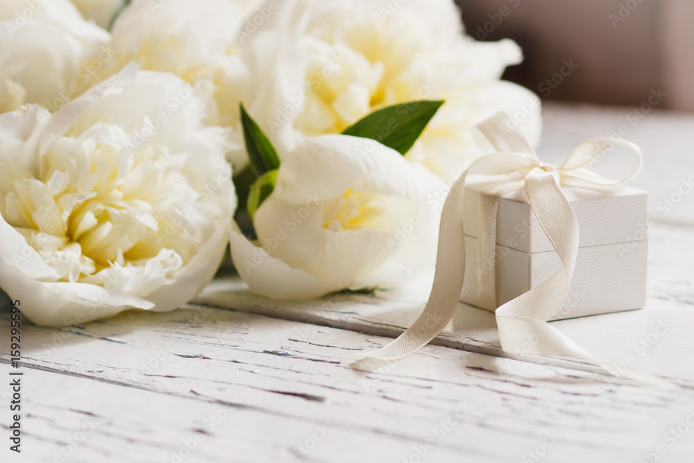 Bouquet of white peonies and present box on the wooden table Bouquet of white peonies and present box on the wooden table