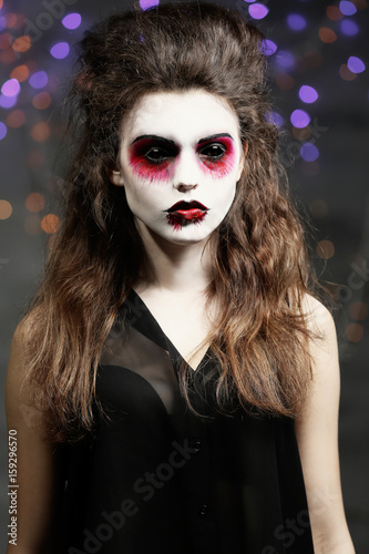 Young woman in color contact lenses, with Halloween makeup at party