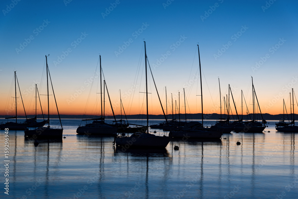 Various sails at sunset in lake Garda, Italy