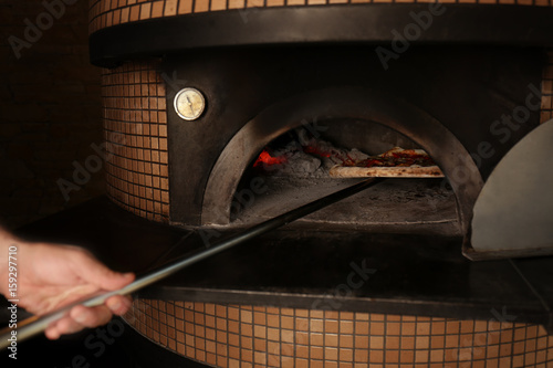 Tasty pizza putting out from oven © Africa Studio