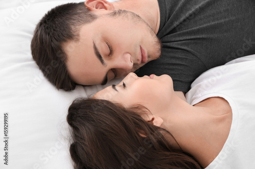Beautiful young couple lying in bed, closeup