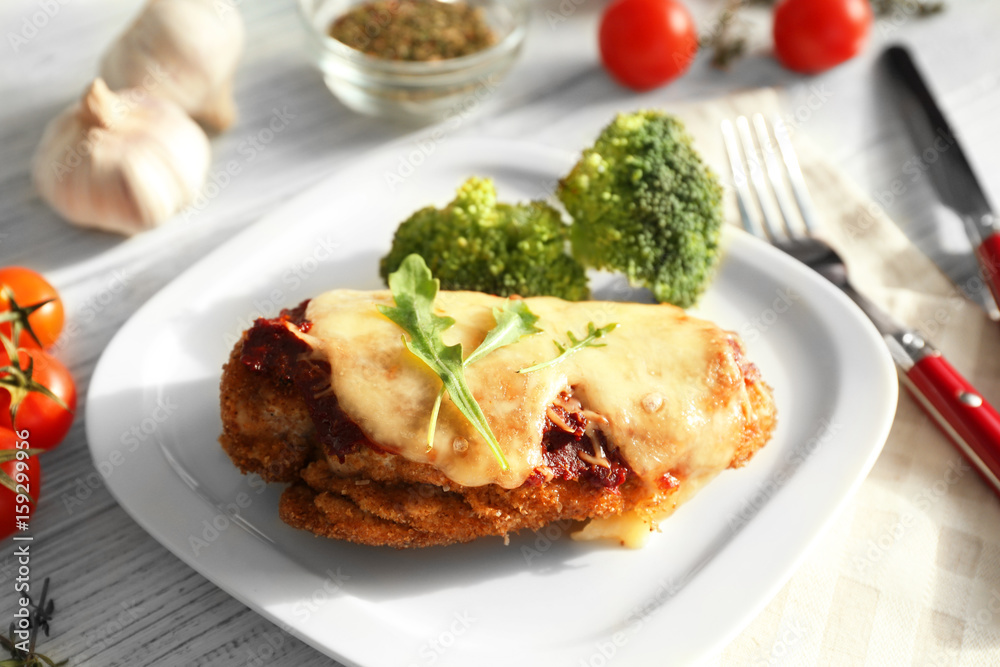Tasty chicken parmesan with broccoli on plate Tasty chicken parmesan with broccoli on plate