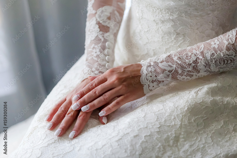 The bride sits putting her hands on each other, the wedding manicure The bride sits putting her hands on each other, the wedding manicure
