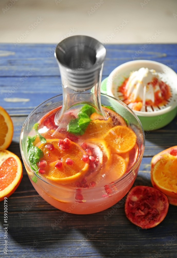 Decanter of fresh cocktail with pomegranate and orange on table Decanter of fresh cocktail with pomegranate and orange on table