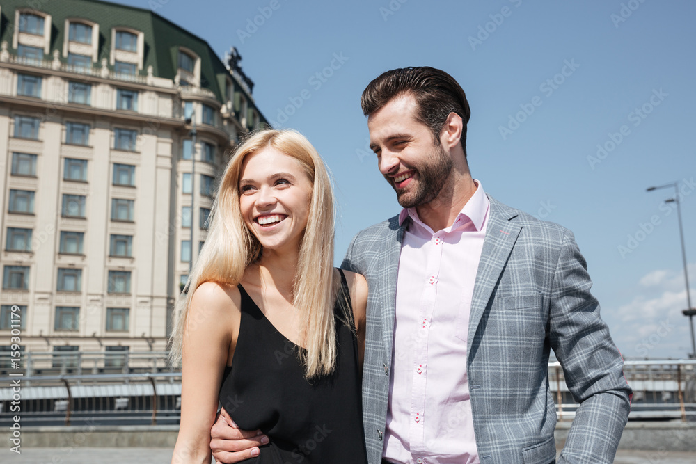 Pretty couple of cheerful man and woman walking in street Pretty couple of cheerful man and woman walking in street