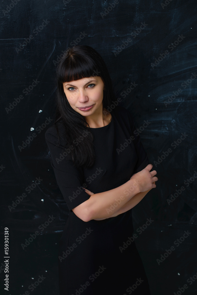 Confident business woman on a black background in a black dress Confident business woman on a black background in a black dress