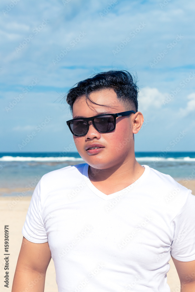 Young asian indonesian man on the beach of tropical Bali island, Indonesia. Young asian indonesian man on the beach of tropical Bali island, Indonesia.