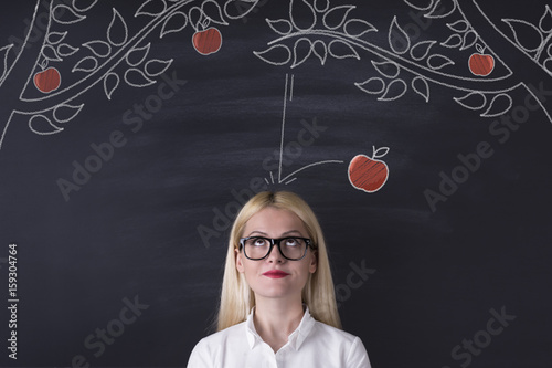 Slika na platnu Business woman and falling apple on the blackboard