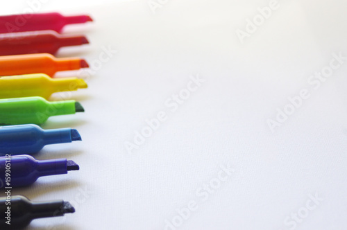 Rainbow colored marker tips on white background