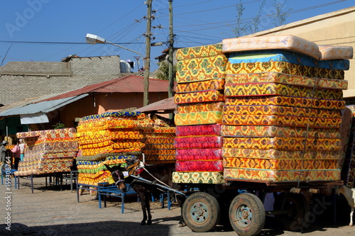 Overworked? A Donkey and Wagon Heavily Loaded With Mattresses 