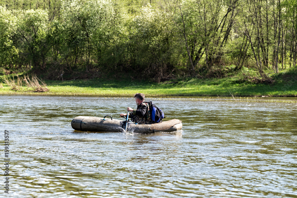 Man in an inflatable boat floats on the river