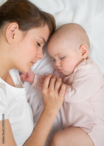 Mother and baby sleep in be...