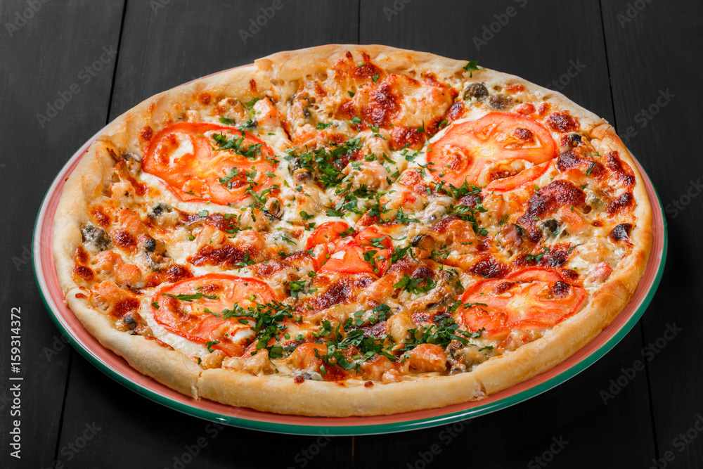 Pizza with chicken, tomatoes, mushrooms, greens and cheese on dark wooden background. Homemade pizza. Top view