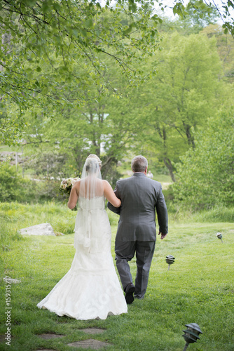 Bride Being Walked Down the Aisle by Her Father at an Outdoor Wedding Ceremony
