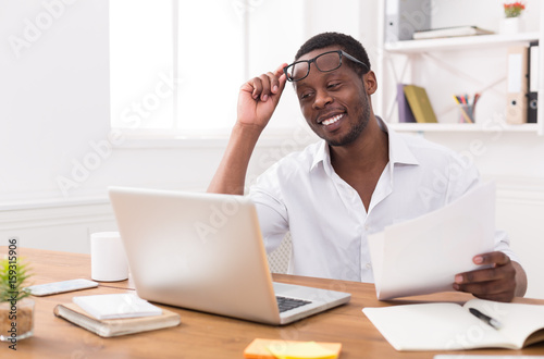Black businessman in office, work with laptop and documents