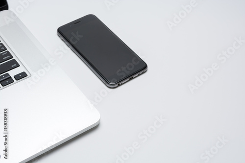 Laptop computer with smart phone on white background