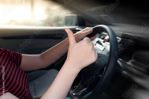 woman sitting in a car seat and making a thumb up sign ,hand making Like Ok sign