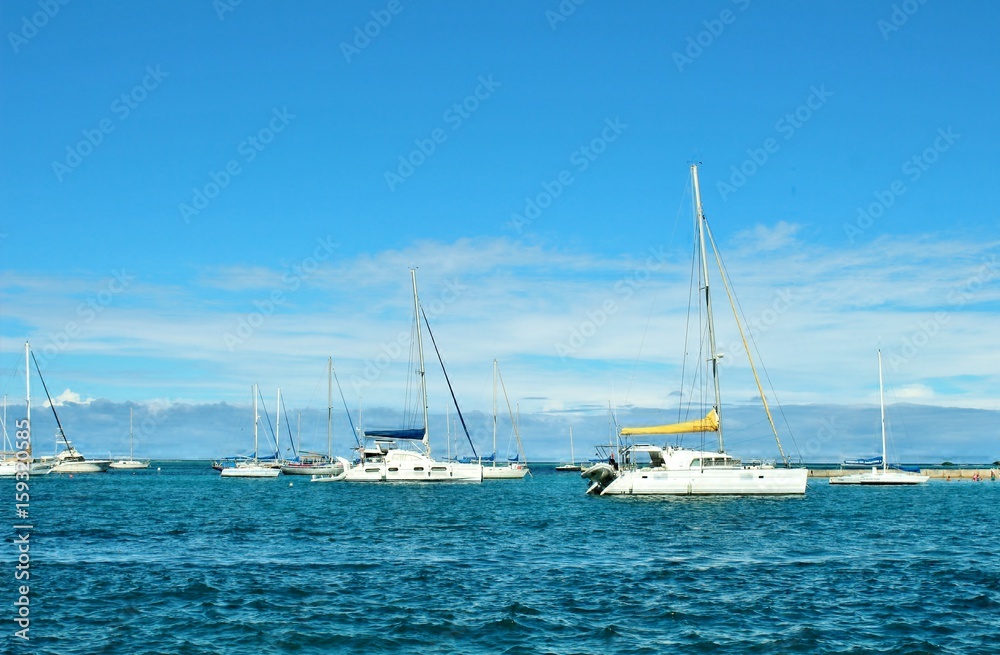 Sail boats on the ocean and a beautiful blue sky background