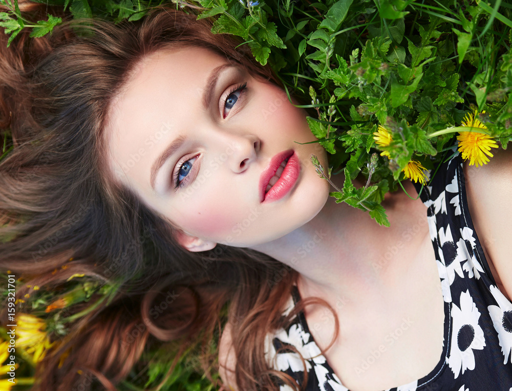 Beautiful young natural well-groomed girl lies on the grass with yellow ...