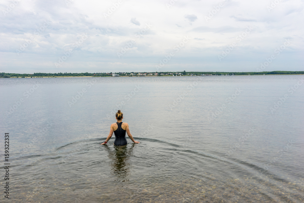 Young woman in a swimsuit goes swimming Young woman in a swimsuit goes swimming