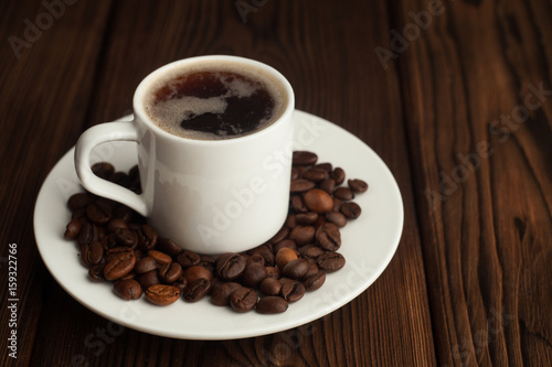 Coffee cup and coffee beans on wooden table © misskaterina