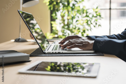 Hands of businessman typing on laptop in office