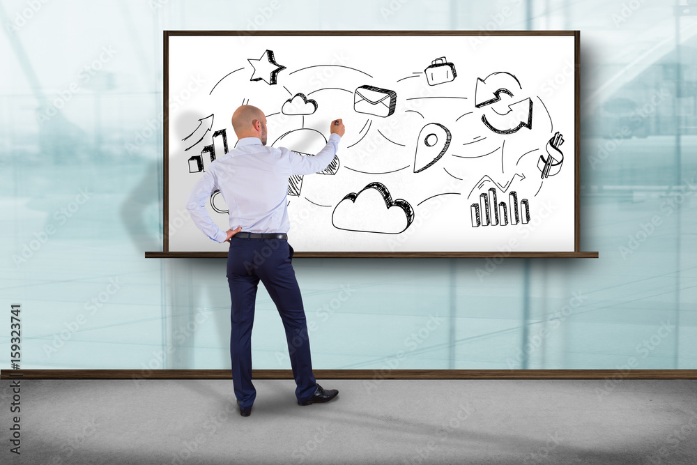 Fototapeta premium Businessman in front of a wall writing on a business reminder interface application - Technology concept