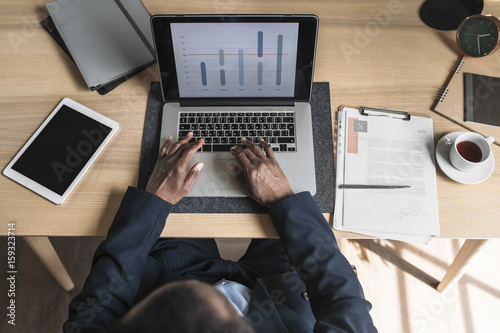 Overhead view of businessman working on laptop in office