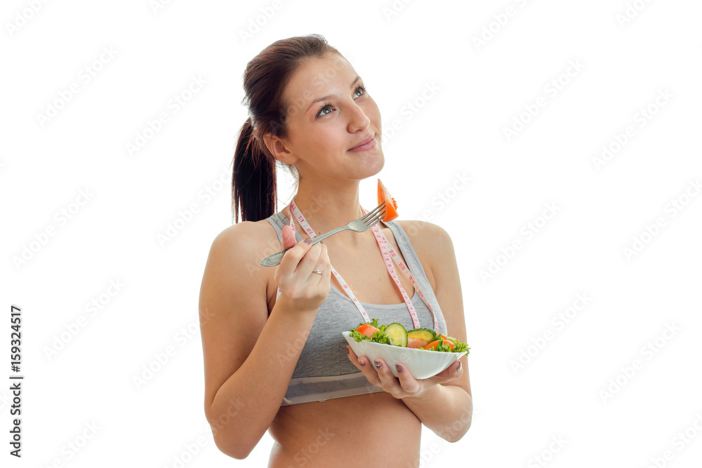 horizontal portrait of a young cute girl that looks up and eats fresh vegetable salad horizontal portrait of a young cute girl that looks up and eats fresh vegetable salad