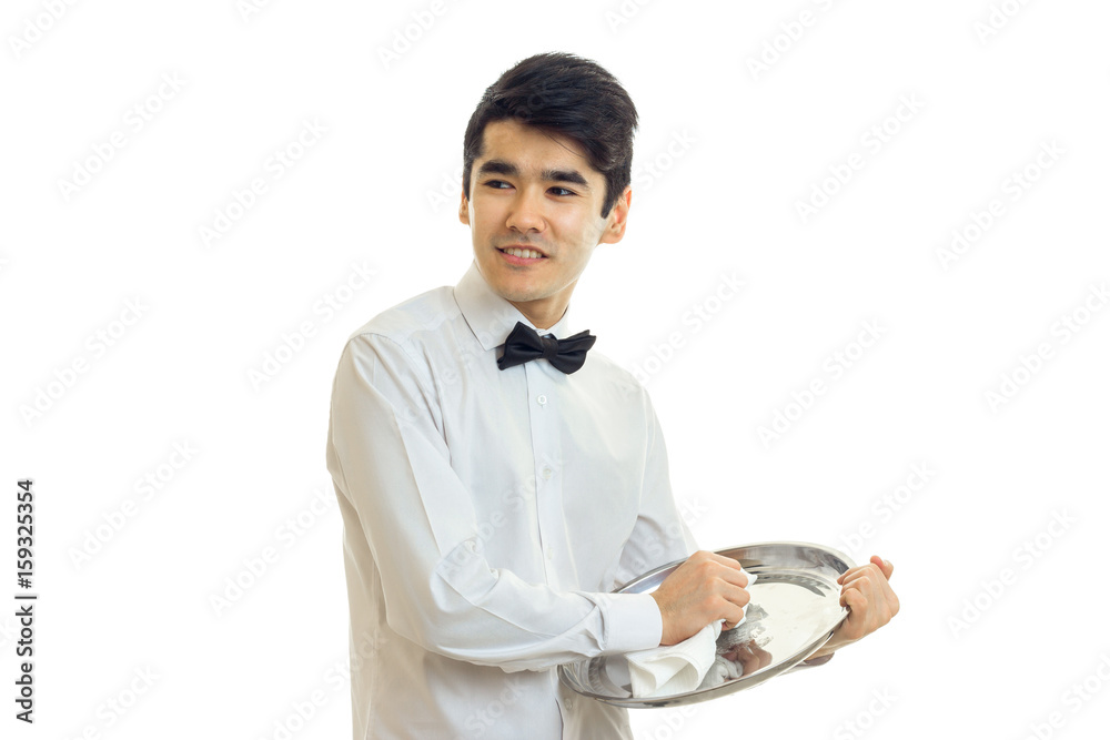 young cute waiter looks sideways smiles and wipes the tray towel young cute waiter looks sideways smiles and wipes the tray towel
