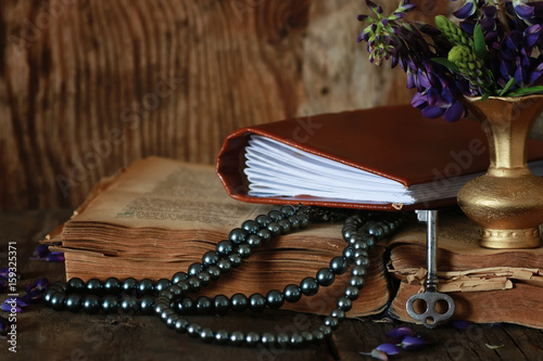 Quran with flower and beads on wooden table