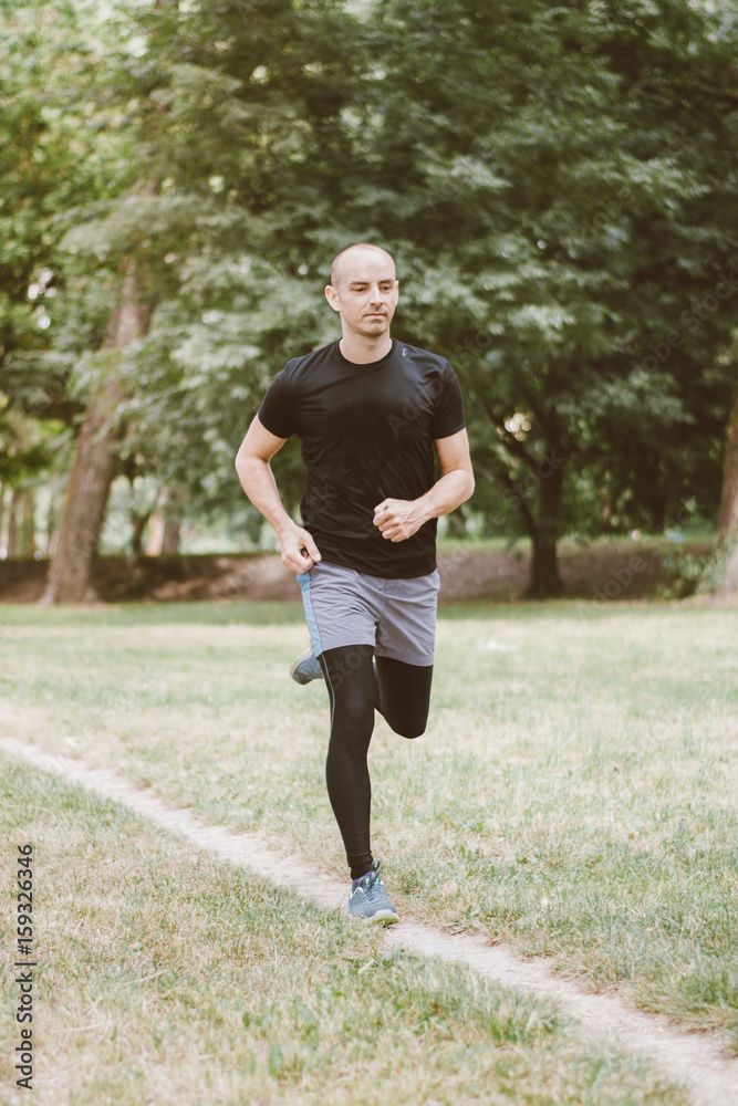 Man running jogging outdoors in park nature Man running jogging outdoors in park nature
