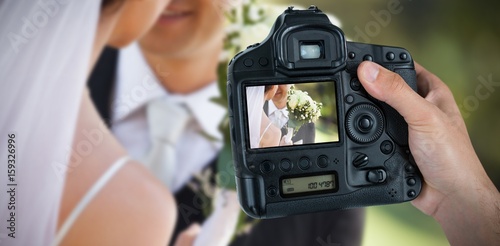 Composite image of cropped hand of photographer holding camera 